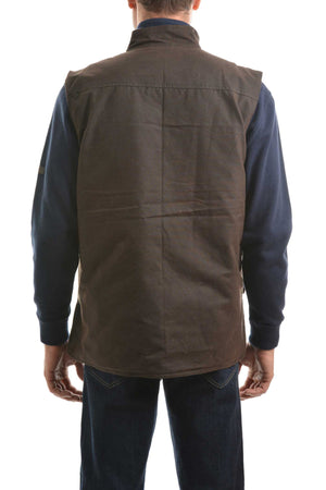 Someone is shown from the back against a white background, wearing a Thomas Cook High Country Oilskin Vest in dark brown over a navy blue long-sleeve shirt and blue jeans.