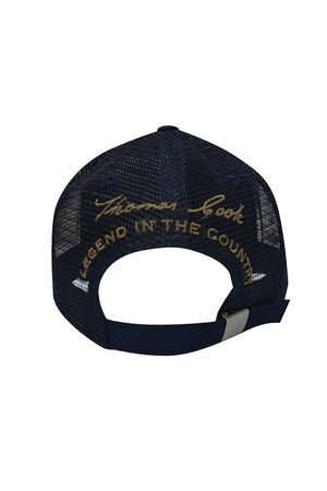 A navy blue Thomas Cook Thomas Trucker Cap seen from the back, displaying yellow "Thomas Cook" and "LEGEND IN THE COUNTRY" embroidery above its adjustable mesh strap.