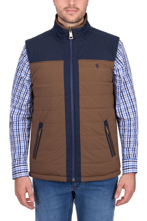 A man wearing the Thomas Cook Toby Revs Vest over a blue and white checkered shirt with blue jeans, standing facing the camera against a white background.