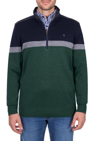 A man wears a Thomas Cook Troy 1/4 Zip Jumper featuring a navy top, gray stripe, and green lower section, styled over a blue checked shirt and blue jeans.