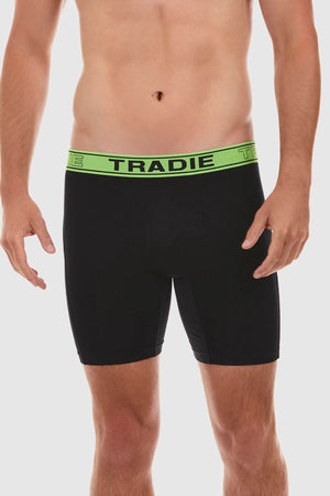 A man is standing against a white background wearing Tradie Bamboo No Chafe Long Leg Trunks made from breathable stretch material. The waistband is neon green with the brand name "TRADIE" printed in bold black letters. His torso is visible from the neck down, highlighting the comfortable fit of the Bamboo No Chafe fabric.
