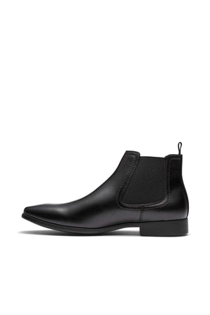 A side view of the UNcut Newlands Boot, a black leather Chelsea boot, showcasing an almond toe shape and elastic gusset with a low heel against a white background. This versatile boot is perfect for any occasion and available in UK sizing.