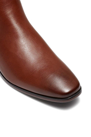Close-up of the toe of an UNcut Newlands Boot with a smooth, polished finish. The adaptable boot showcases an almond toe shape and prominently displays the leather texture against a plain white background.