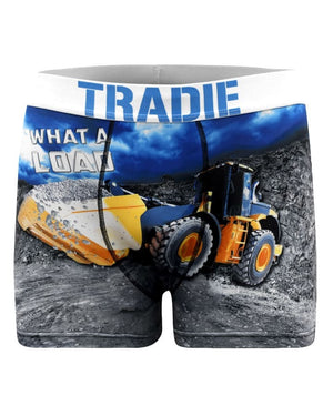 The Tradie Mens Work N Surf Trunk features a graphic yellow bulldozer on rocky terrain, “WHAT A LOAD” on the leg, and "TRADIE" on the waistband. Made with quick-drying fabric for all-day comfort.