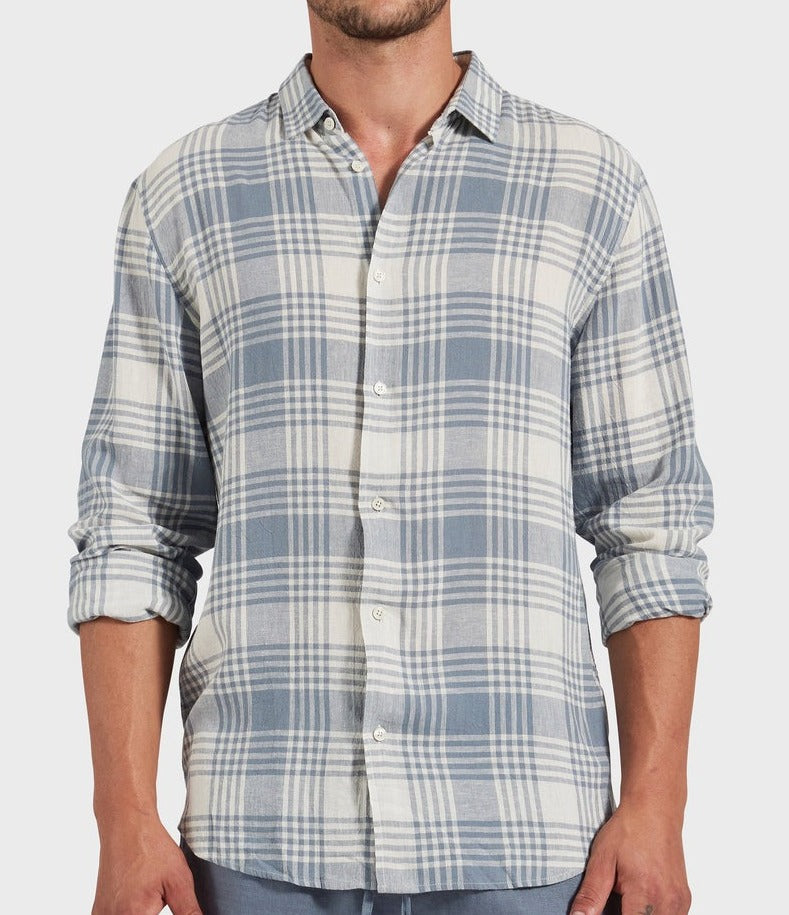 Wearing the Academy Brand Yosemite Shirt, a light blue and white plaid button-up with rolled sleeves made from a linen-viscose blend. Only the torso is visible against a light background, showcasing its relaxed style.