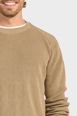 Wearing the Academy Brand Oliver Knit Crew in beige premium cotton ribbed knit over a white shirt, a smiling man’s lower face and upper torso are shown against a light background.