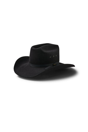 The Akubra Outback Club is a black hat with a wide brim, slightly creased crown, black hatband, and small metal eyelets, shown on a white background with shadow—a style popular in Australian country music.