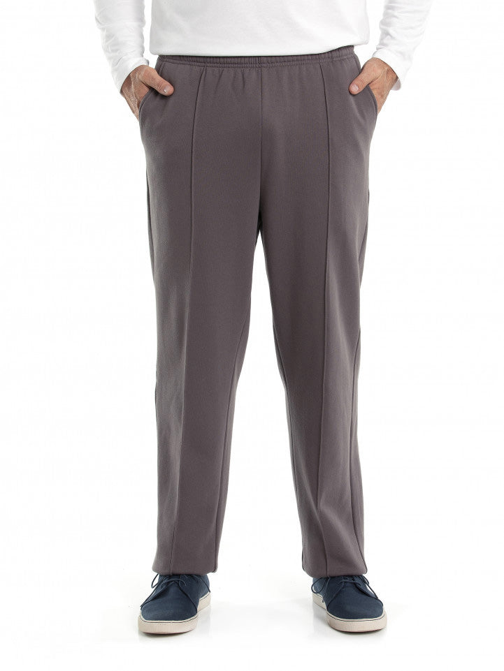 A person is shown from the shoulders down wearing a white long-sleeve shirt, Breakaway Snowy Mt Fleece Pants in gray, and dark blue sneakers with white soles. Hands are in the pants pockets, and the person is standing against a plain white background—perfect casual weekend wear.