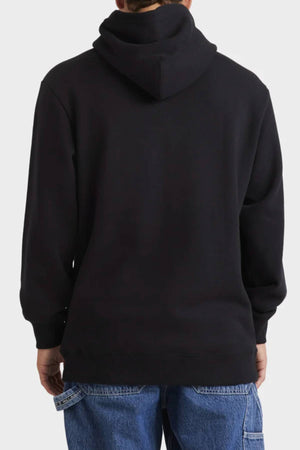 A person is seen from the back in a black Billabong Tonal Boss Pop Hood fleece pullover and blue jeans, standing against a plain light background.