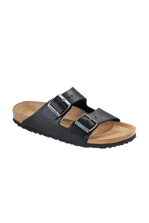 The Birkenstock Arizona is a black slide sandal with two adjustable buckles on the strap and a cork footbed with a textured sole. This sandal boasts a minimalist design and looks comfortable for casual wear.