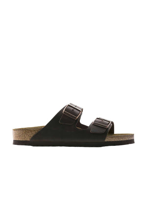 The Birkenstock Arizona is a black sandal designed for casual wear, featuring a cork sole and two wide straps across the top. Each strap is equipped with an adjustable dark metal buckle, and the inside sole is contoured for optimal comfort.