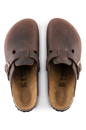 A pair of Birkenstock Boston brown leather slip-on clogs with closed toes, adjustable side buckles, and a contoured footbed is shown from above on a white background.