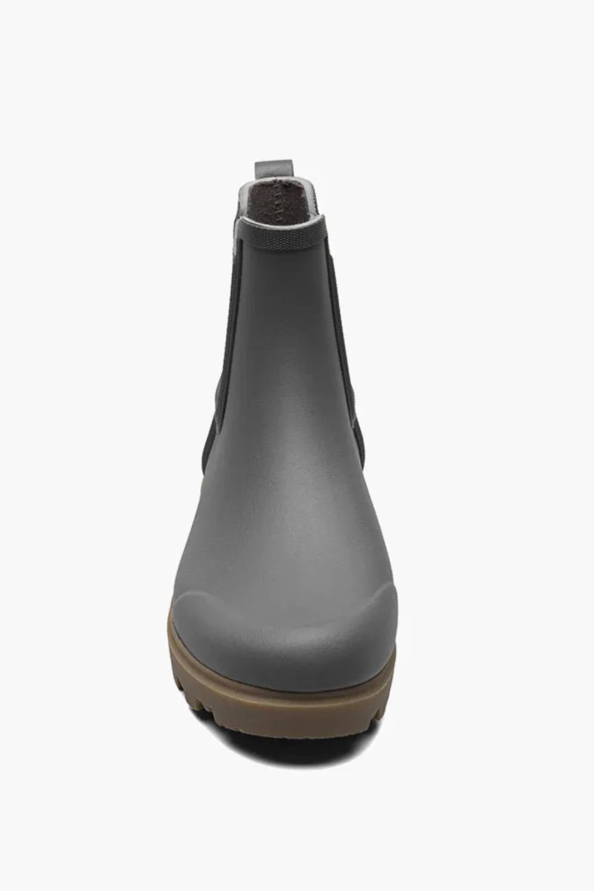 The BOGS Holly Chelsea Waterproof Boots are grey rubber Chelsea boots with a brown sole, shown from the front on a white background. These waterproof boots feature rebound cushioning for all-day comfort.