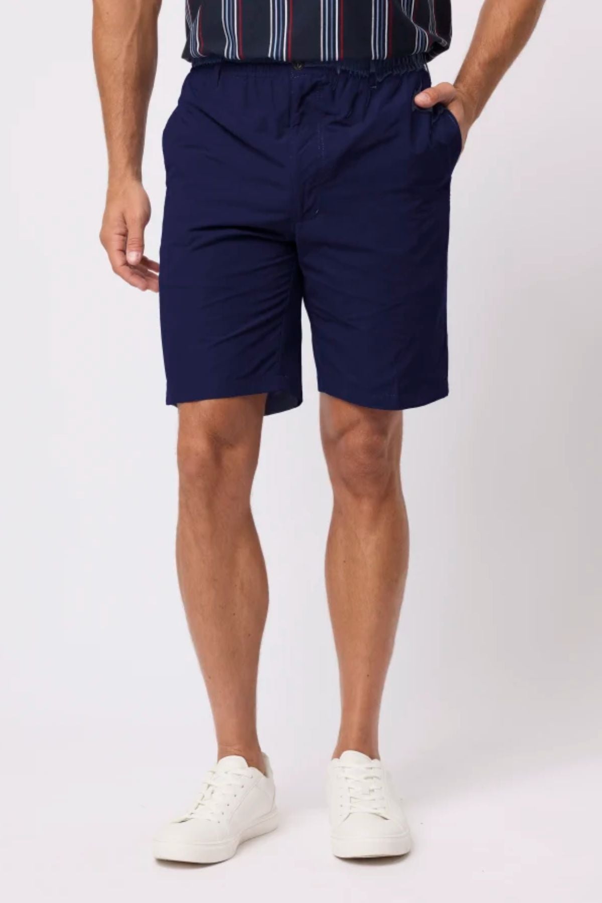 Wearing Breakaway Woodbury Short featuring an adjustable waist, a person in a dark striped shirt and white sneakers stands with one hand in their pocket against a plain light background.