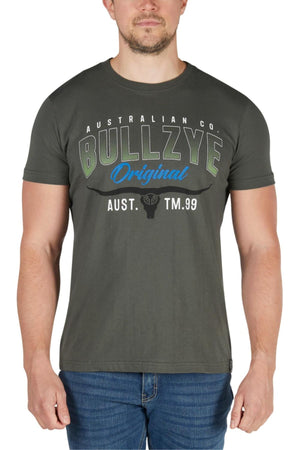 A man in blue jeans wears the Bullzye Original Tee, a dark grey pure cotton jersey shirt featuring "Australian Co. Bullzye Original Aust. TM.99" and a small bull head graphic on the front, in a classic fit style.