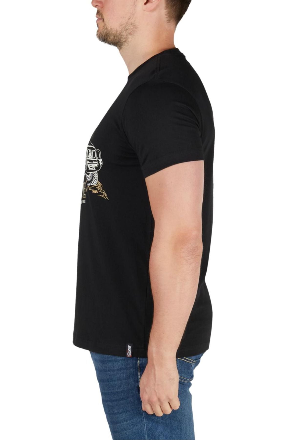 A man in profile facing left wears the Bullzye Dusk Tee, a black cotton jersey t-shirt with a white chest graphic, paired with blue jeans against a plain white background.