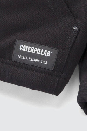 Close-up of a black fabric label stitched onto the CAT Hooded Sherpa Lined Jacket, featuring the "CATERPILLAR" logo in white text above "PEORIA, ILLINOIS U.S.A.