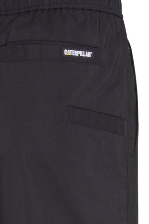 Close-up of CAT Hydraulic Short in black, featuring a Caterpillar logo patch above the front pocket, elastic waistband, and visible seam.