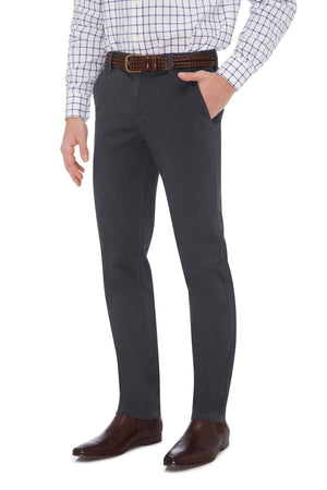 A person is standing with one hand in their pocket, wearing a white checkered shirt, brown belt, and the City Club Hammond Place Pant paired with brown leather shoes. The image captures the City Club vibe from mid-thigh down to the shoes.