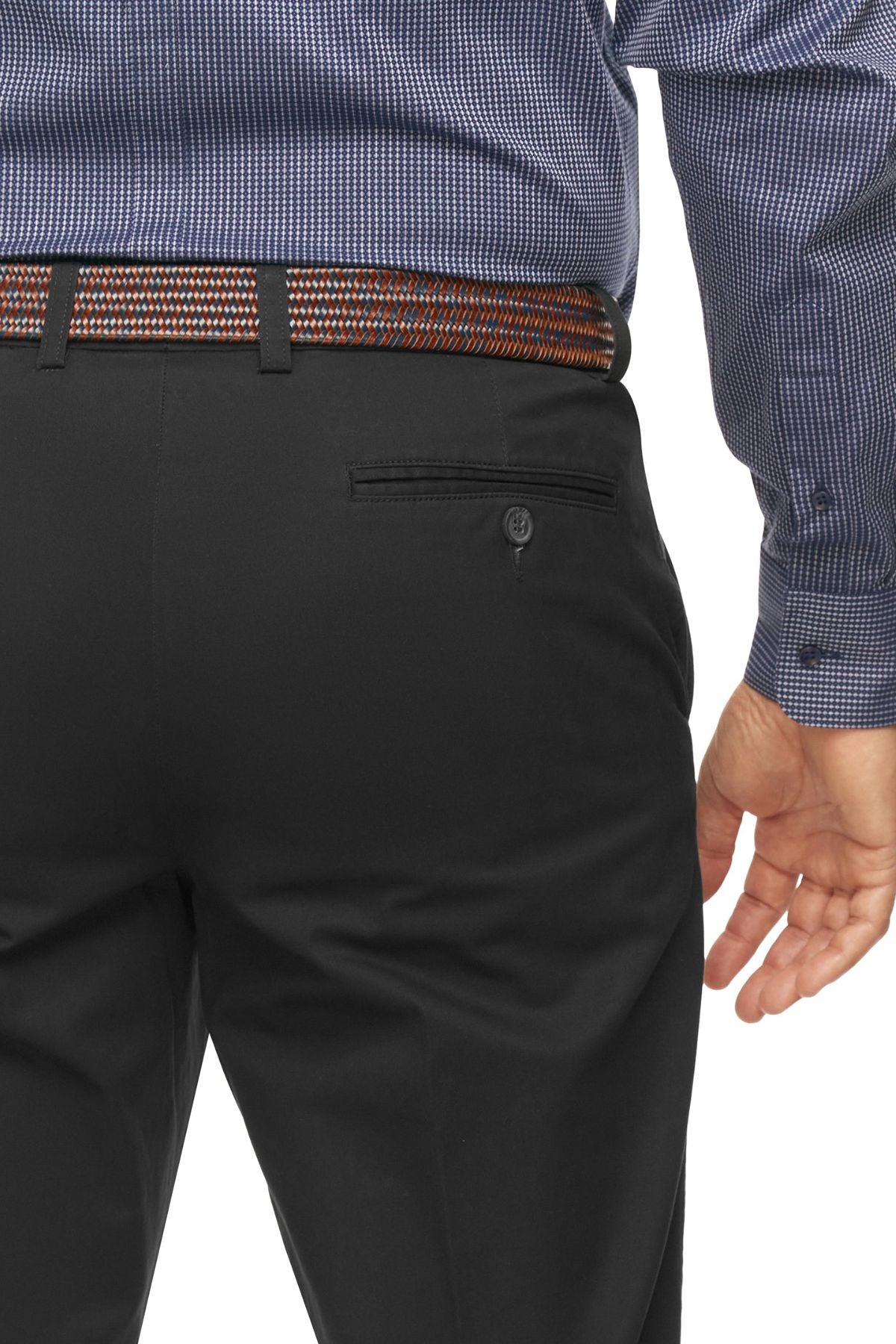 A man is seen from the waist down, donning a dark, patterned long-sleeve shirt and City Club Mariner Harbour Pants made of Cotton and Spandex. His right hand rests by his side, and he sports a patterned belt with elasticated sides for added comfort.