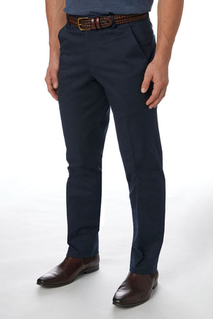 A person wearing the stylish and comfortable navy blue City Club Navigator 1770 Pant made from a blend of cotton and spandex, complemented by a brown woven belt and brown dress shoes, is standing against a plain white background. The image is cropped at the shoulders, focusing on the lower torso and legs.