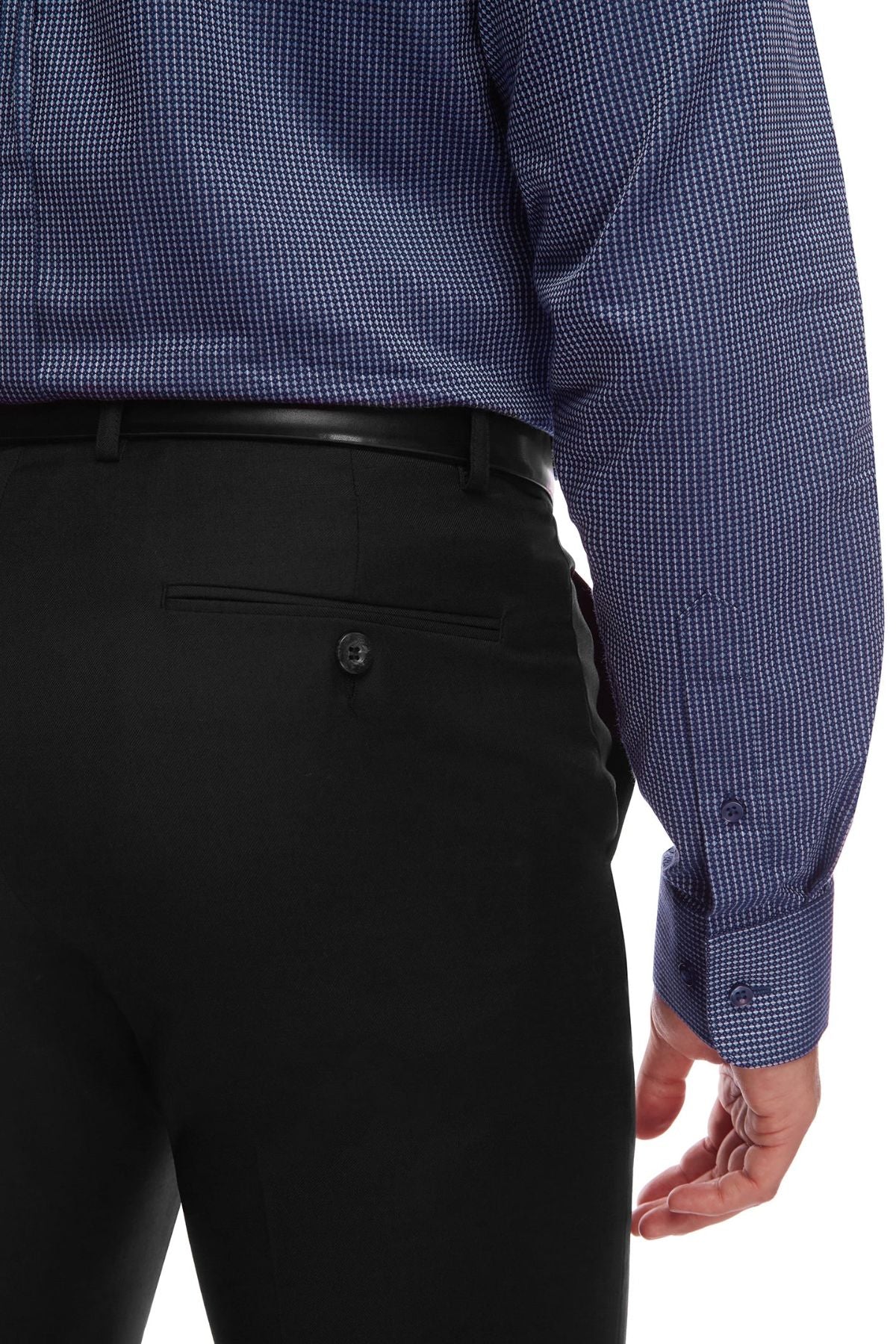 A close-up of a person wearing a blue, long-sleeved, checkered shirt and black City Club SHIMA 1007 pants with a comfortable fit. The image shows the back and side view, focusing on the details of the fabric and the button closure of the flexi-waist pants' back pocket. The person's hand is visible at their side.