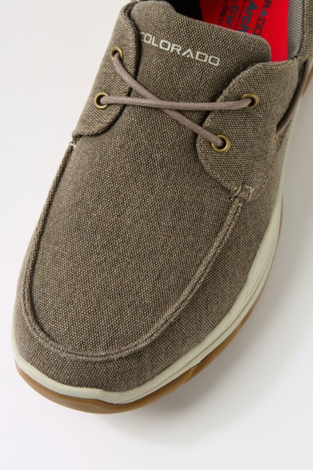 Close-up of the Colorado Kanebo Canvas Shoe: brown canvas upper with white stitching, tan rubber outsole, gold eyelets, arch support, and "COLORADO" embroidered in white near the laces for a casual yet supportive look.