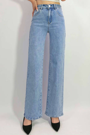 Person wears Country Denim Straight Leg Stretchy Jean in high-waisted, light blue style with black pointed-toe shoes, standing against a plain white background. The upper body is partially out of frame.