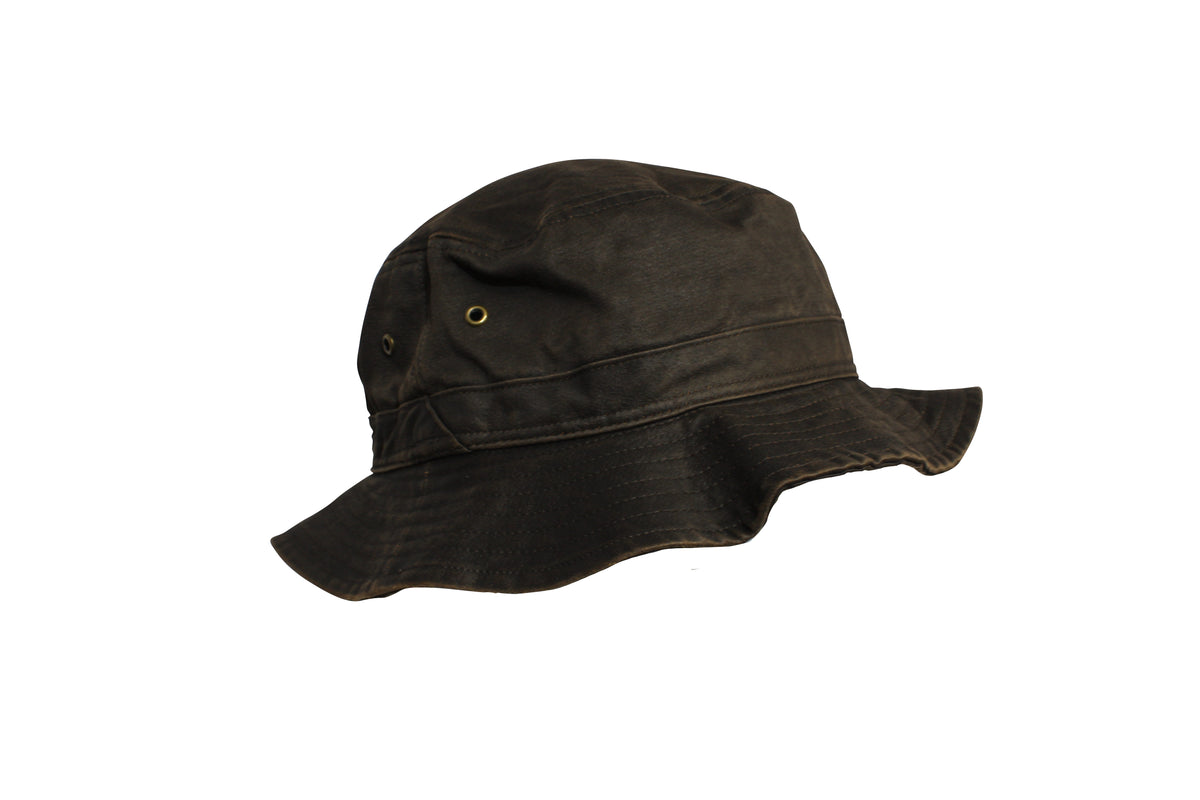 The Flinders Weathered Cotton Bucket Hat features dark brown weathered cotton, a wide floppy brim, and dual metal side eyelets—perfect for outdoor activities with UPF50+ protection.