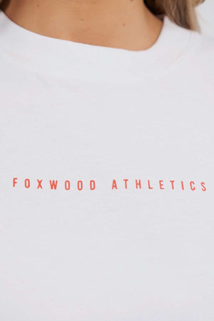 Close-up of the Foxwood Captain Tee, a white cotton T-shirt featuring "FOXWOOD ATHLETICS" in bold red uppercase letters across the chest—ideal for casual wear.