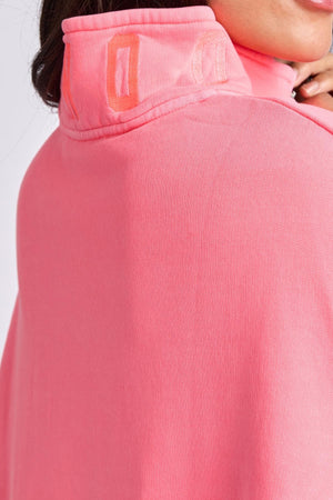 Close-up of a person wearing the Foxwood College Zip Crew in bright pink soft cotton, with orange embroidery on the high collar. The image showcases the back and side of the embroidered collar and upper shoulder area.