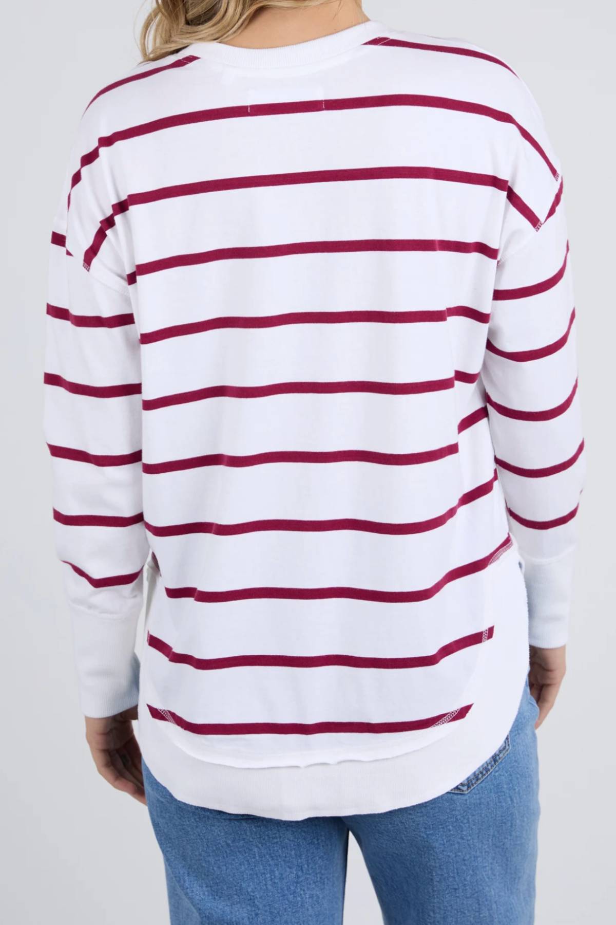 A person is shown from the back wearing a relaxed fit Foxwood Farrah Stripe Long Sleeve with soft Pima Cotton and horizontal red stripes, paired with blue jeans.