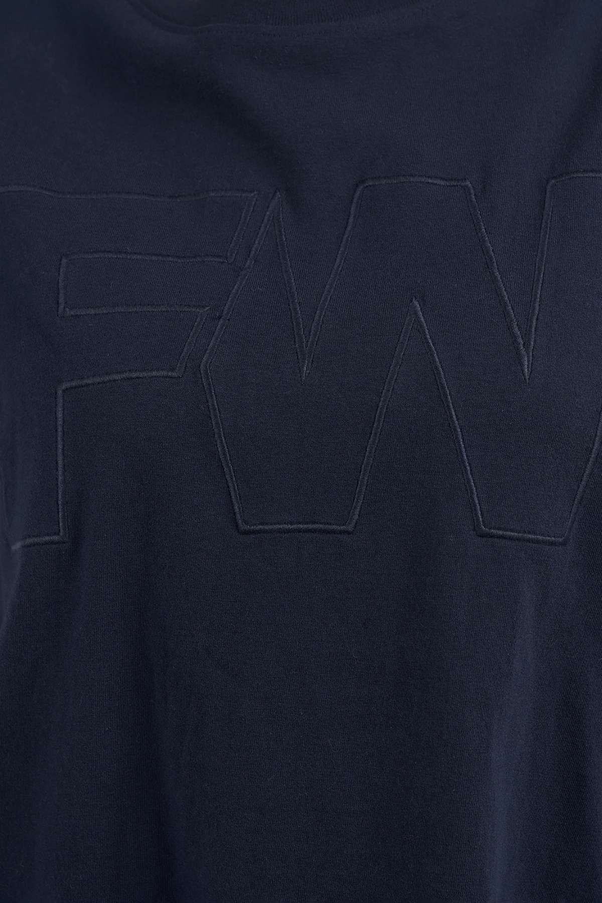 Close-up of a navy blue Foxwood FW Embroidery Tee, featuring large "FW" letters in satin embroidery. Made from 100% cotton.