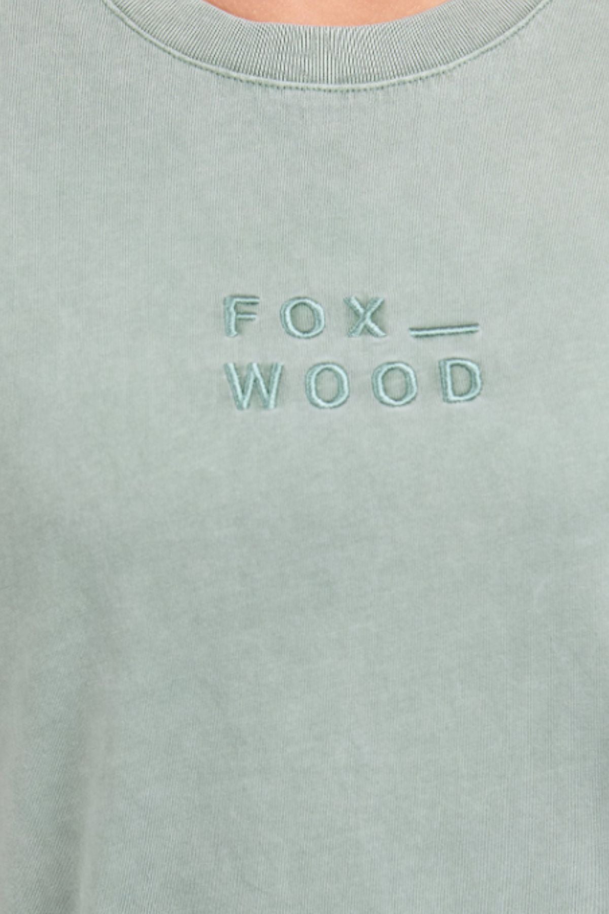 Close-up of the Foxwood Huntleigh Oversized Tee in light green, relaxed fit, featuring "FOX _ WOOD" embroidered in capitals on the chest.