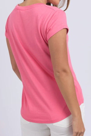 A person is shown from the back wearing the Foxwood Manly Tee in bright pink and white pants against a plain light gray background, highlighting this casual women's t-shirt.
