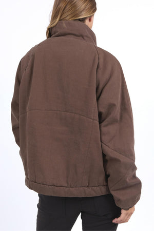 A person with light brown hair is seen from behind wearing the Foxwood Rosalee Jacket, featuring a cropped slouch design, paired with black pants against a plain white background.