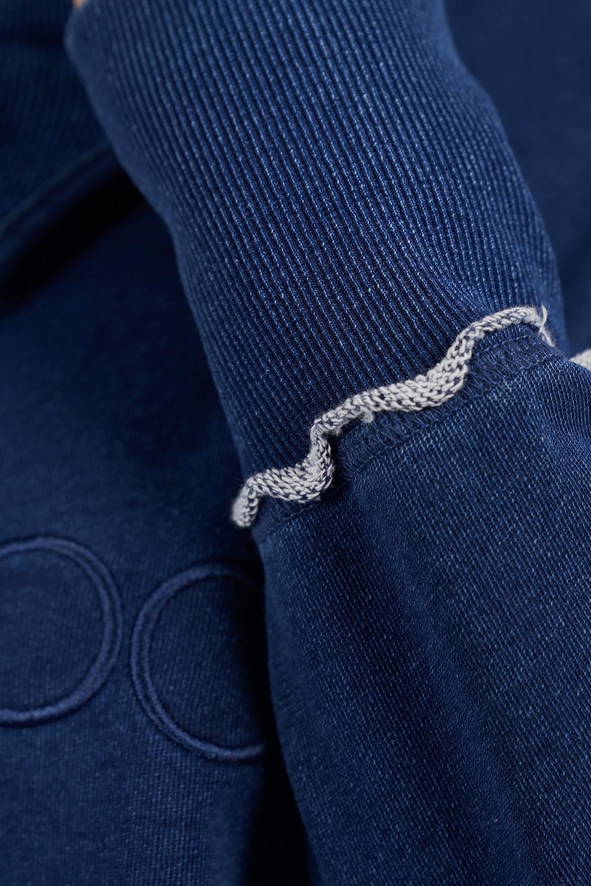 Close-up of the Foxwood Simplified Crew's navy ribbed sleeve, showcasing a wavy light gray seam near the cuff. Made from 100% cotton, this soft, textured fabric offers a relaxed fit.