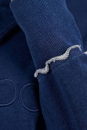 Close-up of the Foxwood Simplified Crew's navy ribbed sleeve, showcasing a wavy light gray seam near the cuff. Made from 100% cotton, this soft, textured fabric offers a relaxed fit.