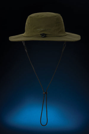 The FXD CP-14 Boonie Hat in olive green provides sun protection, features a wide brim and an adjustable chin strap, and is displayed against a dark background with a blue gradient at the bottom.
