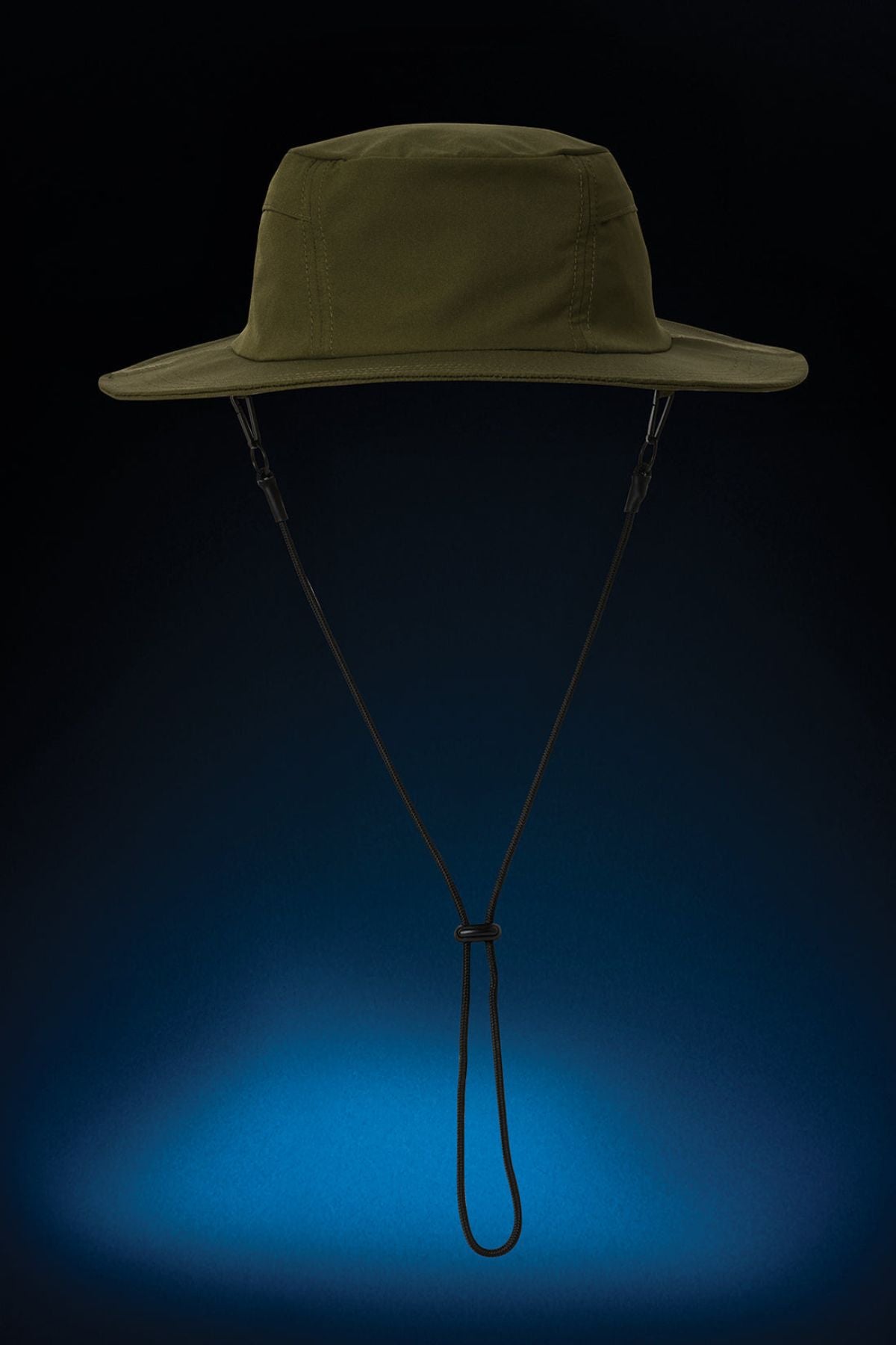 The FXD CP-14 Boonie Hat, in olive green with a chin strap, is designed for outdoor work and sun protection. Itโs shown against a dark background with blue light below, highlighting its shape and details.