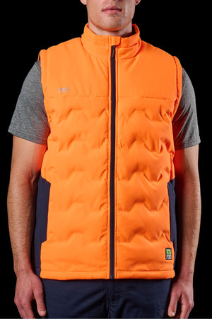 A person wears the FXD WO-6 Hi Vis Insulated Puffer Vestβa bright orange, zipped outdoor vest with logo patchesβover a grey short-sleeve shirt against a black background.