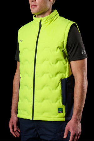 A person wears the FXD WO-6 Hi Vis Insulated Puffer Vest in bright yellow with black zipper and accents, featuring "FXD" branding on the chest and lower front, over a black short-sleeve shirt. The background is black.