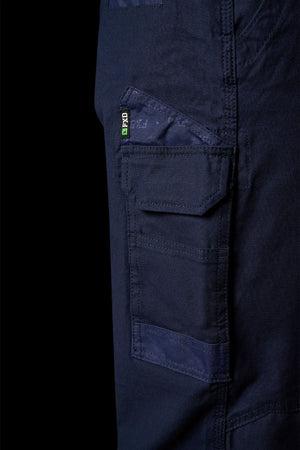 Close-up of FXD WP-3L Loose Fit Stretch Canvas Work Pants in dark blue, featuring side pockets with flaps, visible stitching, and a small black and green PXG tag near the upper pocket.