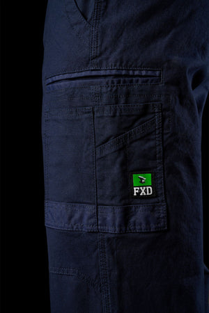 Close-up of the side pocket detail on FXD WP-3L Loose Fit Stretch Canvas Work Pants in navy, showing visible stitching and a green/black FXD logo patch. These stretch pants offer comfort and durability.