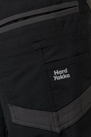 Close-up of dark-colored Hard Yakka Raptor Mid Short pocket with Active Fit stretch waistband for comfort, reinforced stitching, multiple pockets, and a prominent side pocket featuring the brand's logo.