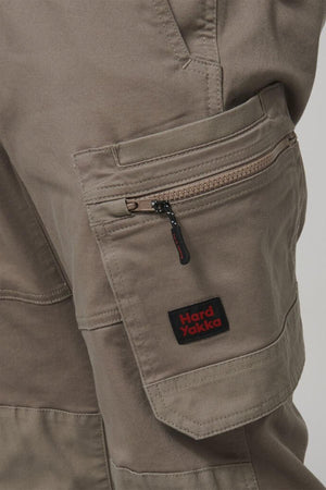 Close-up of the Hard Yakka Tough Maxx Pant’s brown cargo pocket, featuring a visible zipper, detailed stitching, multiple pockets, and a black-and-red Hard Yakka label on the pocket flap.