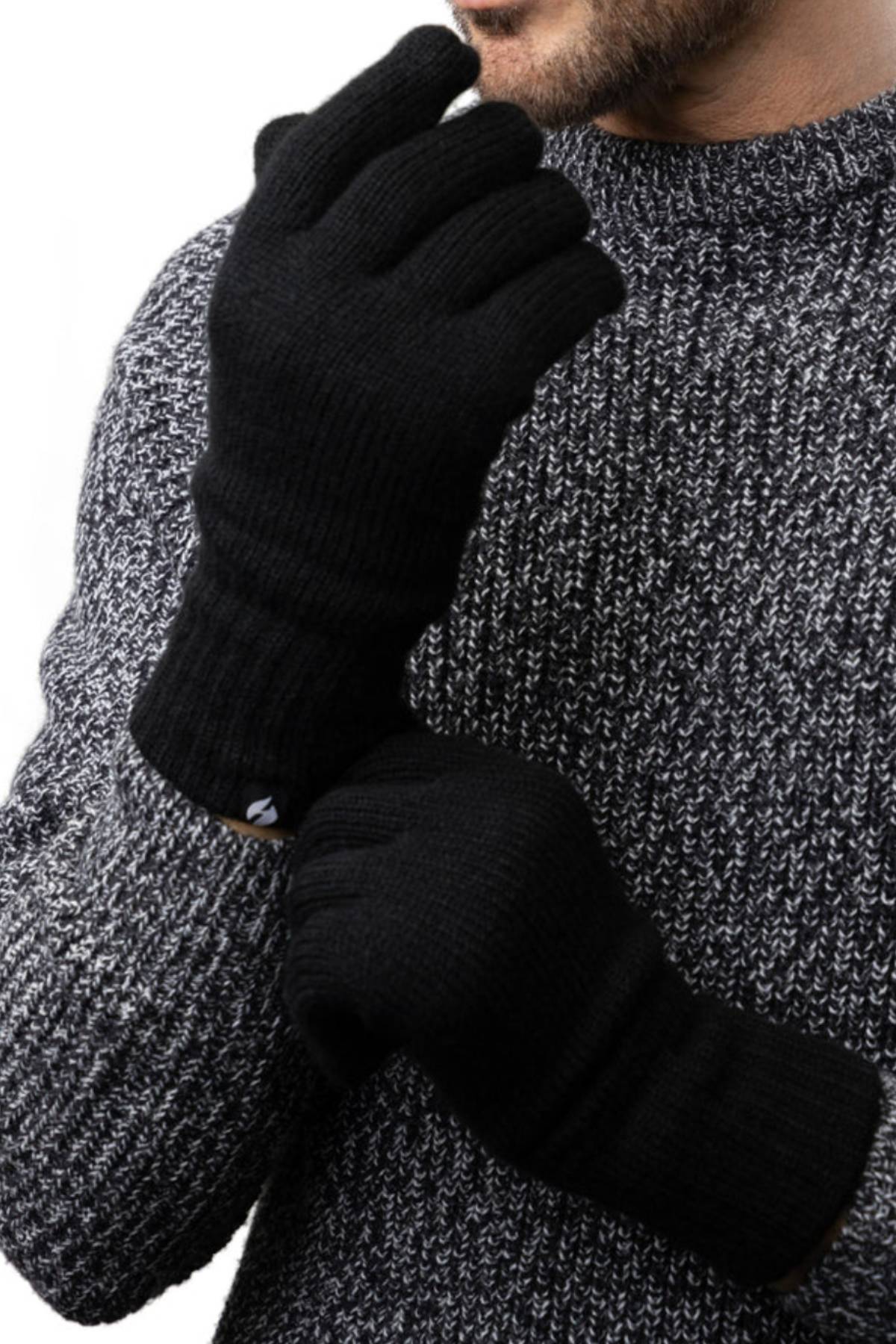 A person in a chunky gray knit sweater adjusts one black Heat Holders Oslo Mens Thermal Glove with the other hand. Only the lower half of their face and upper body are visible in the photo.