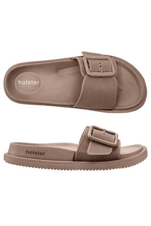 Holster Laze vegan sandals in light brown feature a textured strap with a large buckle, molded footbed, and ridged water-resistant sole. The "holster" brand name appears on the insole and side.