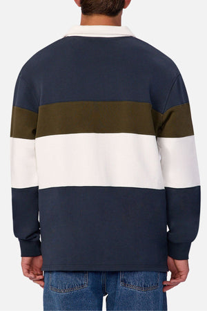 A person is seen from the back wearing the Industrie The Stanstead Tracktop with navy, olive green, and white stripes, styled in a contemporary casual look, paired with classic blue jeans.