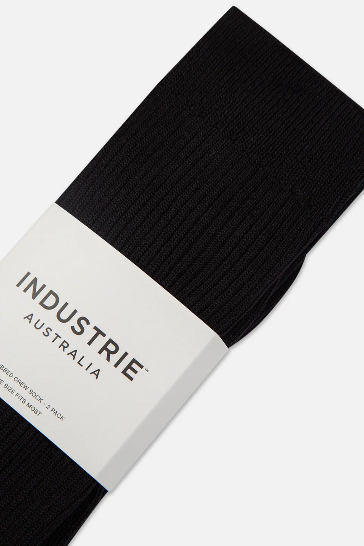Close-up of Industrie Crew Sock 2pk in black, neatly folded with a ribbed texture and partially wrapped in a white "INDUSTRIE AUSTRALIA" paper band. Comfortable crew socks shown packaged together.
